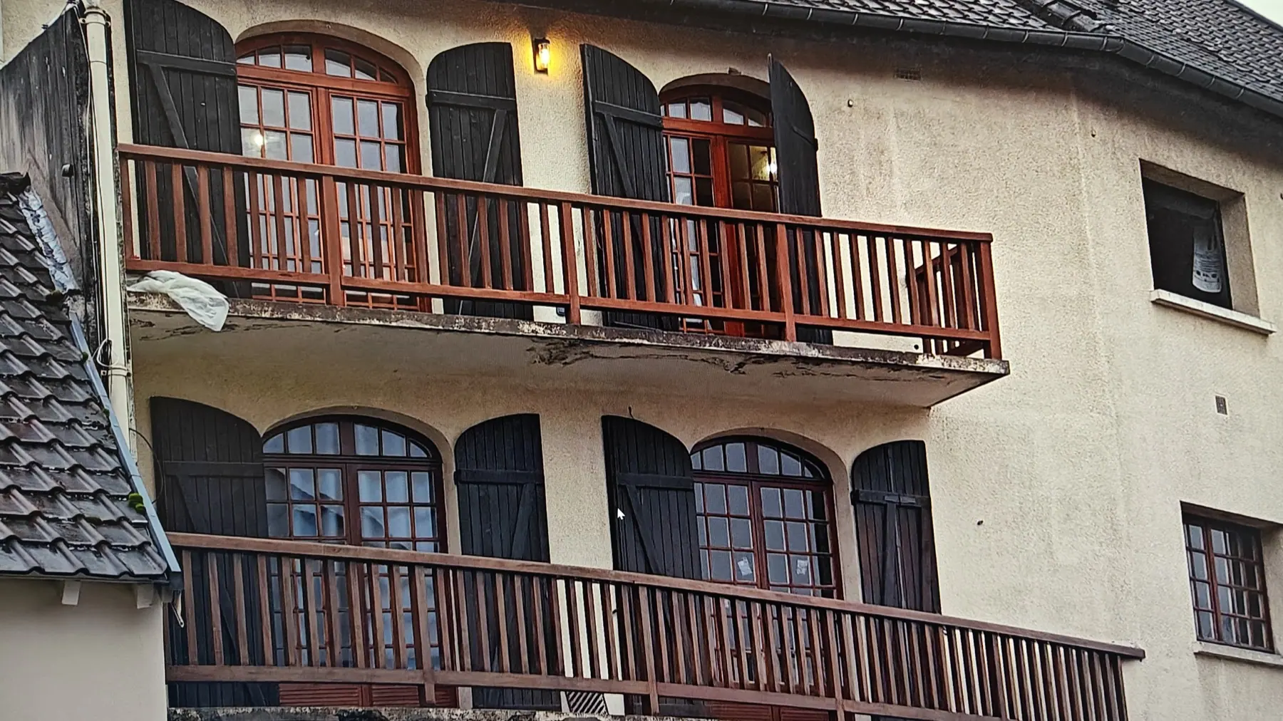 Façade d’un immeuble avec balcons en bois et fenêtres cintrées