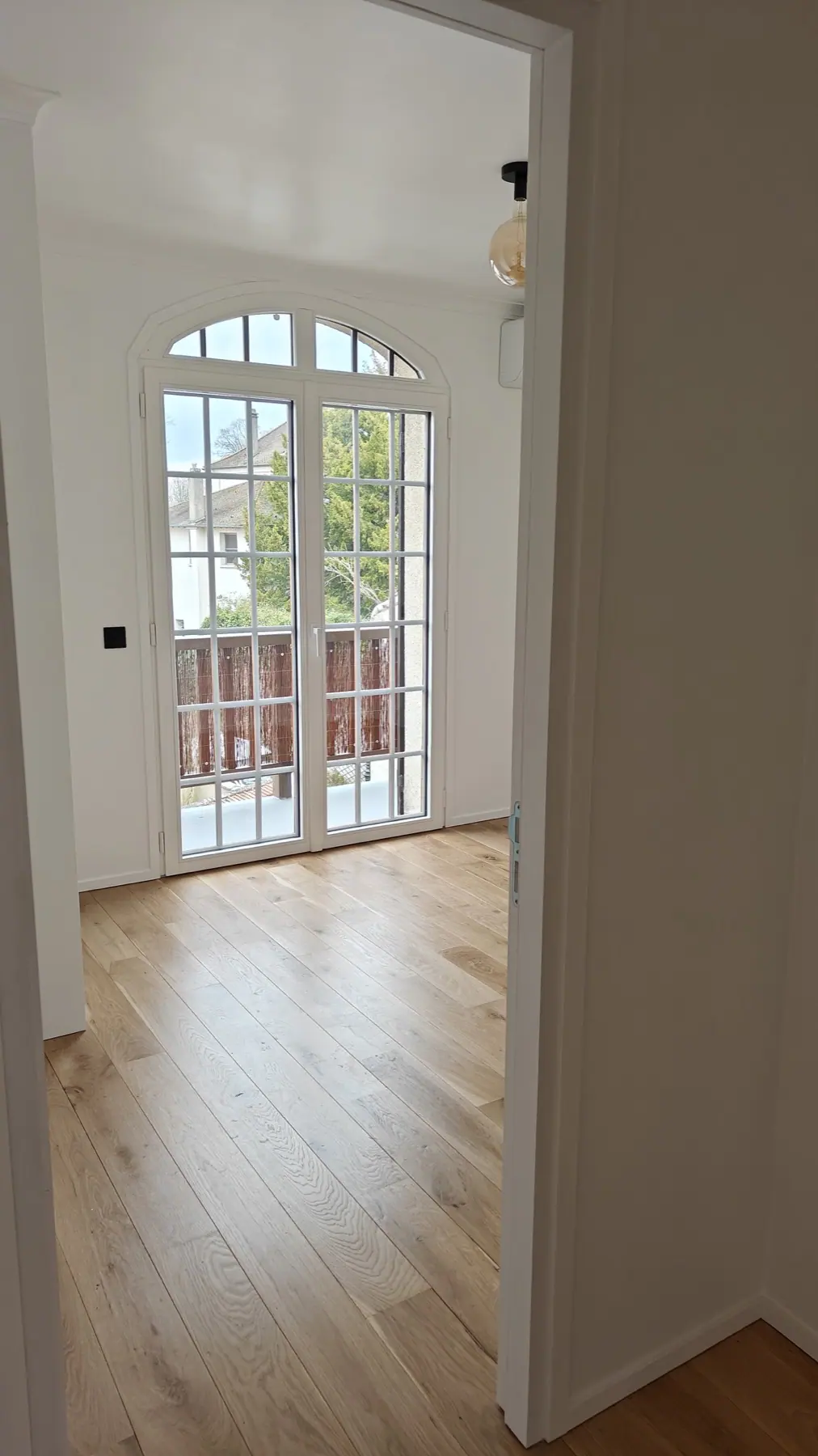 Fenêtre cintrée et porte-fenêtre ouvrant sur le balcon