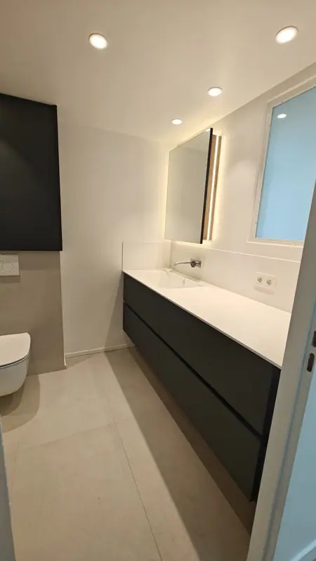 Salle de bains avec spots encastrés et meuble vasque noir
