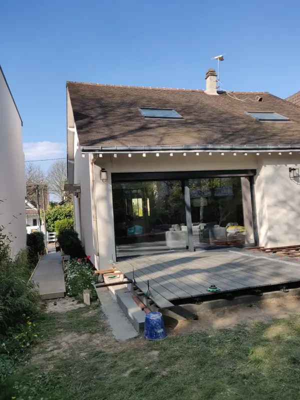 Terrasse en lames composites devant une maison rénovée